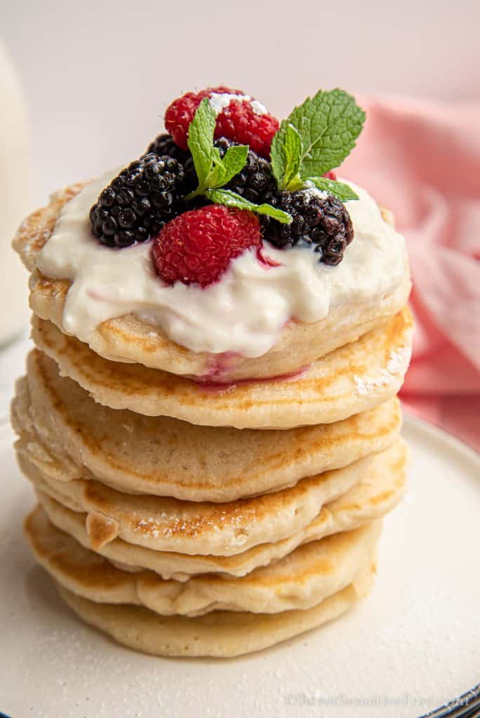 close up of pancake stack topped with fresh berries