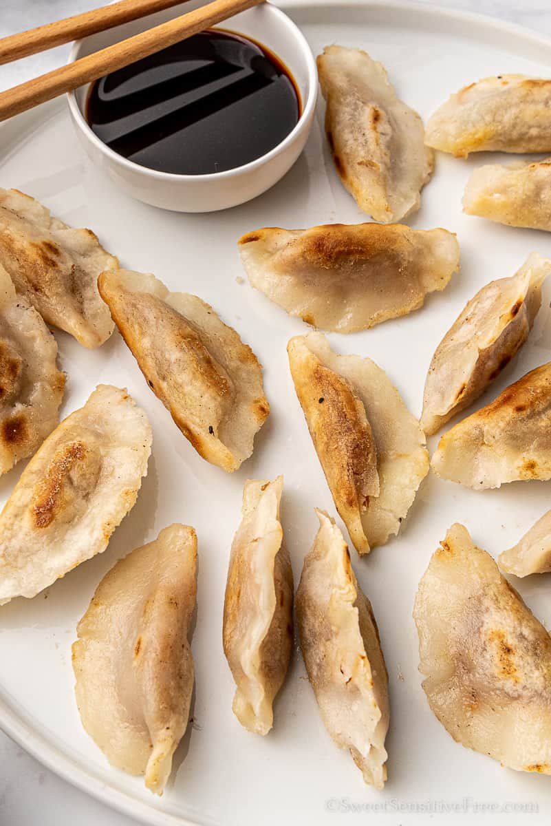 dish of gluten free chinese dumplings with soy sauce and chop sticks
