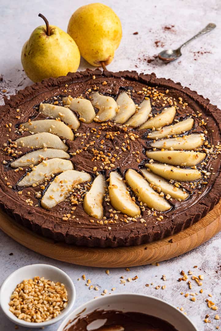a gluten free chocolate tart covered with pears and chopped almonds