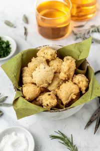 bowl of savory gluten free vegan herb fritters with drinks