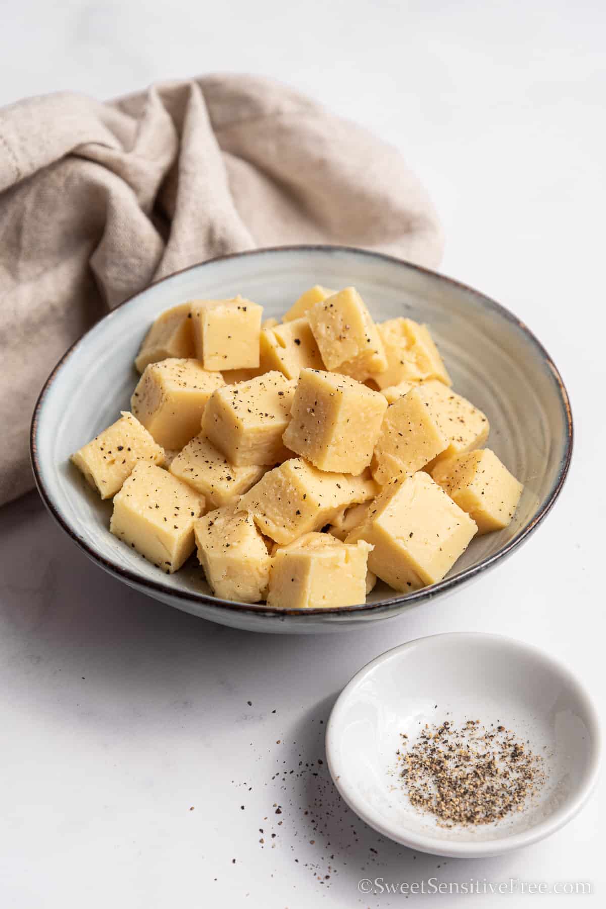 cubes of chickpea tofu in small bowl with pepper
