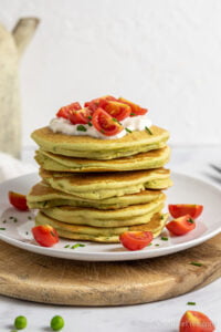 closeup of green pancakes with tomatoes